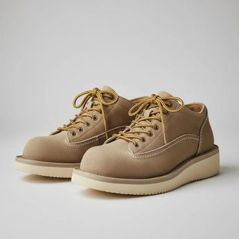 Vintage suede men’s low-top boots — handcrafted tan suede shoes with wedge sole, minimalist studio background.
