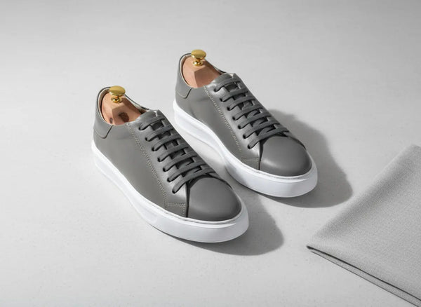 Close-up of gray full-grain leather on Elegante sneakers, smooth grain and hand-finished details.