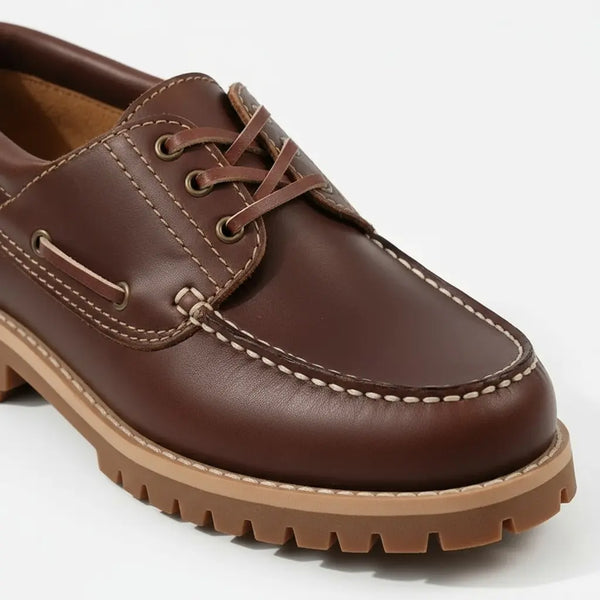 Side detail of men’s brown leather boat shoes with slip-resistant sole and smooth full-grain finish.