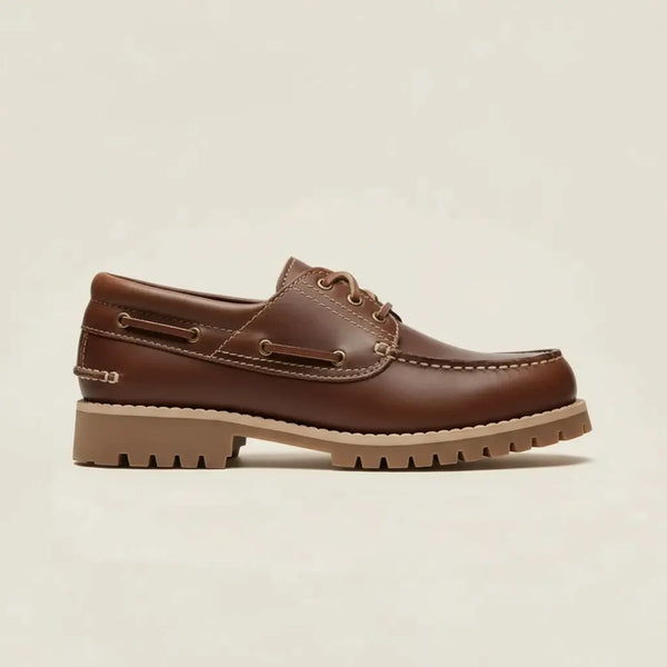 Studio view of handcrafted brown leather boat shoes — classic moc-toe and low-profile boat sole.
