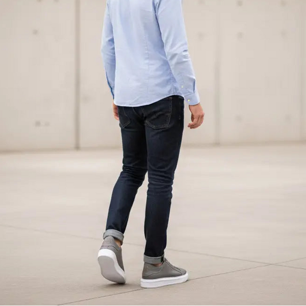 Casual gray leather sneakers for men paired with jeans — clean weekend style.