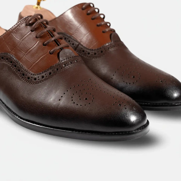 Macro detail of Marquis Oxford – premium brogue detailing and polished brown leather Oxford construction.